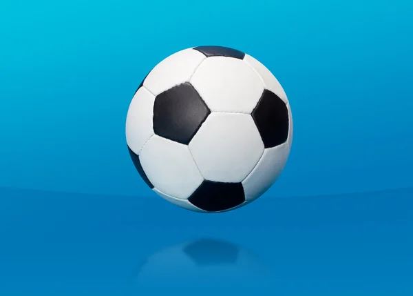Футбольный мяч над синим — стоковое фото