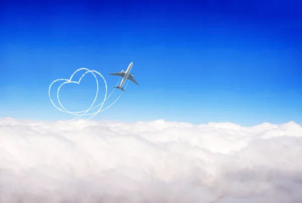 Aircraft draw a heart in the sky. Plane flies over clouds against  blue sky background. Love concept for traveling the world