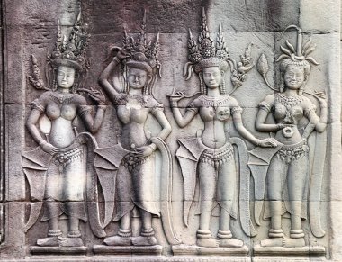 Dört kadın dansçı apsara ile duvar oyma, ünlü Angkor Wat kompleksi, Siem Reap, Kamboçya. Yatay arkaplan, taş dokusu ve dans eden kızlarla kabartma. UNESCO dünya mirası sahası