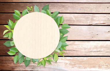 Yeşil yapraklar ve ahşap dokular üzerine yuvarlak kağıt. Ekolojik kağıt desenli yatay afiş. Tahta kalaslar, geri dönüştürülmüş karton malzeme etiketi ve yeşil yaprak. Uzayı metin için kopyala. Şablonu düzenle