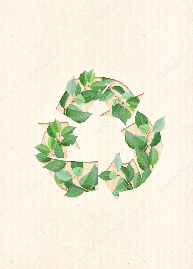 Ecology and zero waste concept. Arrows recycle symbol and green leaves on cardboard texture. Vertical banner with eco paper texture. Recycled carton material. Copy space for text. Mock up template