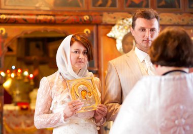 Gelin ve damat için rahip Ortodoks düğün sırasında dinlerken