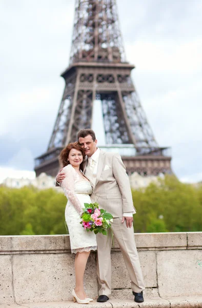 Glad gift par i paris, poserar nära Eiffeltornet — Stockfoto