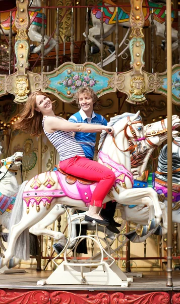 Alegre joven pareja enjyong su paseo en merry-go-round — Foto de Stock