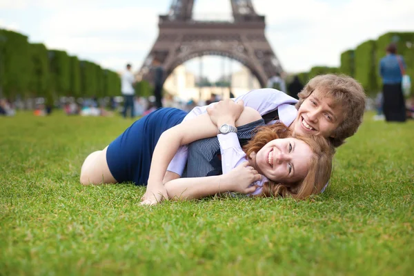 Laughing couple lying on the grass in Paris — Stock Photo, Image