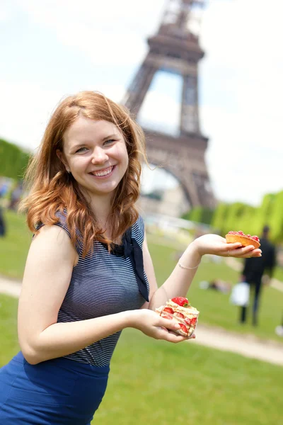 Giovane ragazza allegra con deliziose torte francesi vicino al Eiffel — Foto Stock