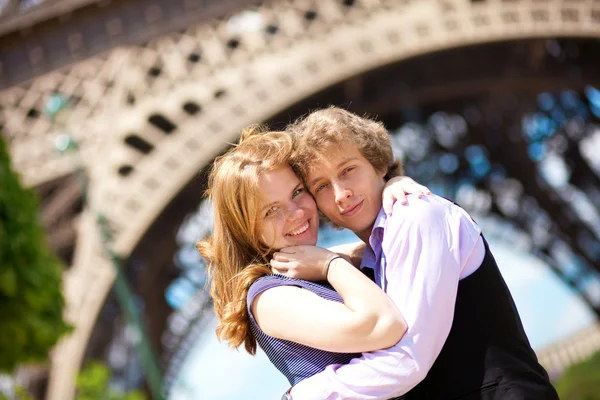 Vacaciones en París. Joven pareja romántica abrazándose bajo el Eiffe —  Fotos de Stock
