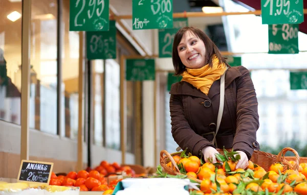 Vacker ung flicka köpa mandariner på marknaden — Stockfoto