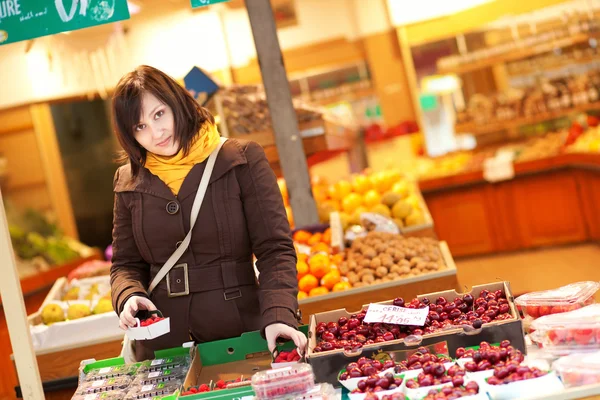 Vacker ung kvinna köpa frukt på marknaden — Stockfoto