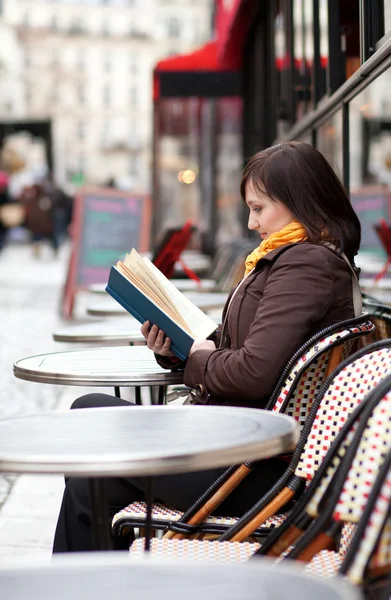 Güzel genç kız Paris Caddesi café'kitap okuma — Stok fotoğraf