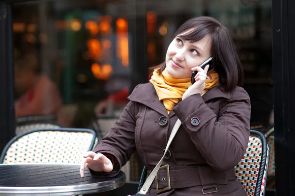 Beautiful young tourist in Paris sitting in street cafe and talk — Stock Photo, Image