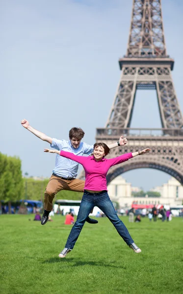 Junges Paar springt in der Nähe des Eiffelturms — Stockfoto