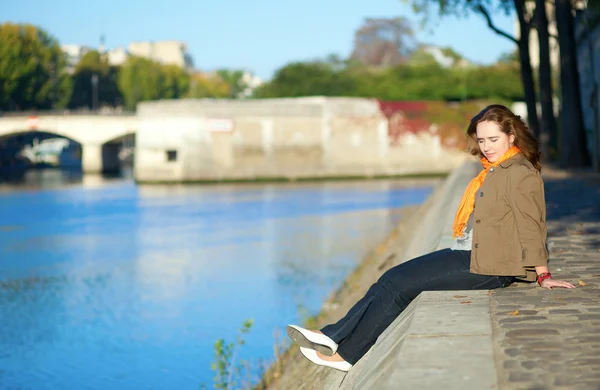 Beautiful girl sitting at the embankment in Paris by early morni — Stock Photo, Image