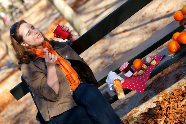 Belle jeune fille buvant du thé chaud dans le parc à l'automne — Photo