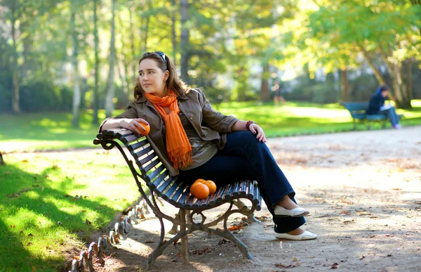 Schöne Mädchen mit Orangen sitzt auf der Bank in Paris by fal — Stockfoto