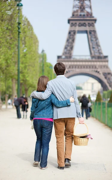Young couple going to have a picnic by the Eiffel Tower Royalty Free Stock Images