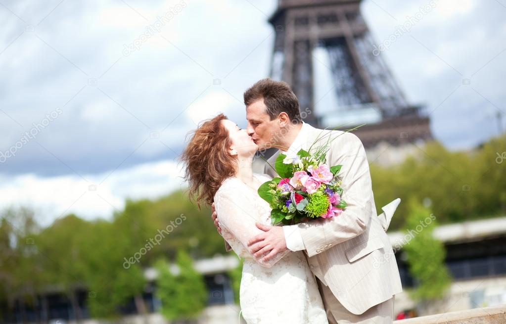 Wedding in Paris. Happy newlywed couple kissing near the Eiffel