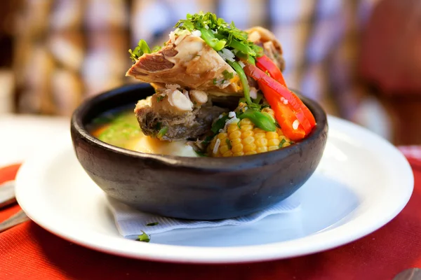 Чилийский суп из казуэлы подается в традиционной глиняной тарелке — стоковое фото