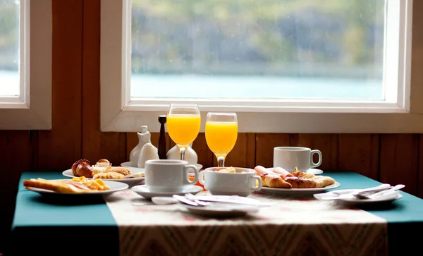 Delicioso desayuno servido en una mesa cerca de la ventana en d lluvioso —  Fotos de Stock