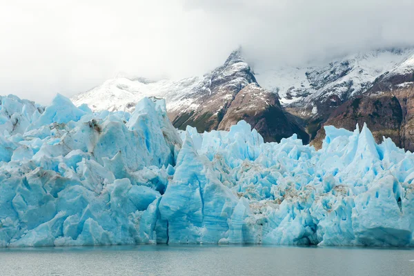 Kék jéghegyek és a havas hegyek a szürke gleccser Torres del — Stock Fotó