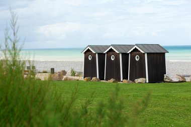 Three cabanas on a beach in Normandy, France clipart