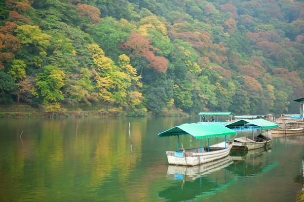 在秋天在岚山，京都，日本的桂河上的船 — 图库照片