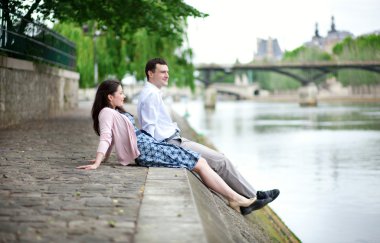 Joyful couple is sitting on the embankment