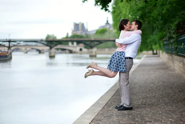 Feliz casal romântico está abraçando perto do Sena, menina está pulando — Fotografia de Stock