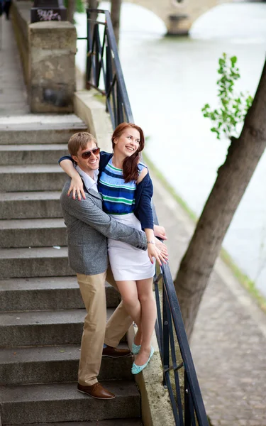 Cheerful couple on the stairs at the Seine embankment in Paris — Stock Photo, Image