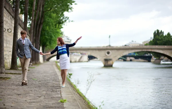 Pareja está caminando por el terraplén del Sena en París, chica es bala —  Fotos de Stock