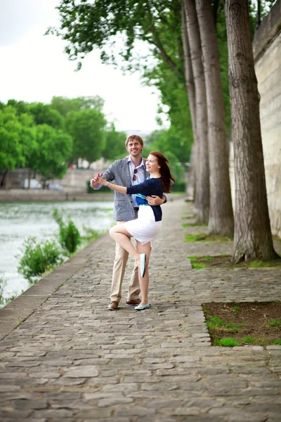 Positieve lachen paar is dansen op de seine embankment in p — Stockfoto