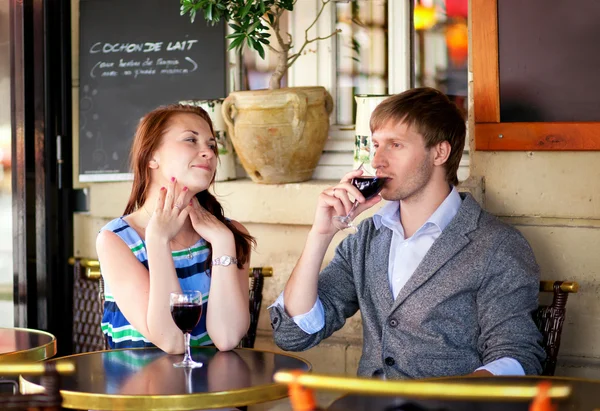 Hermosa pareja bebiendo vino tinto en un café francés — Foto de Stock