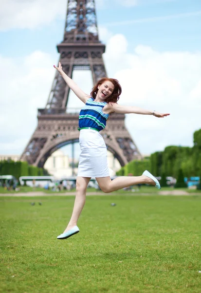 Happy beautiful girl jumping near the Eiffel Tower in Paris — Stock Photo, Image