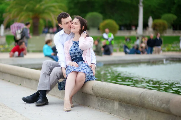 Positiva paret sitter av vattnet i luxembourg-trädgården av par — Stockfoto