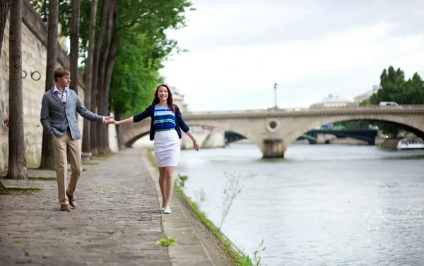 Couple is walking by the Seine embankment in Paris — Stock Photo, Image