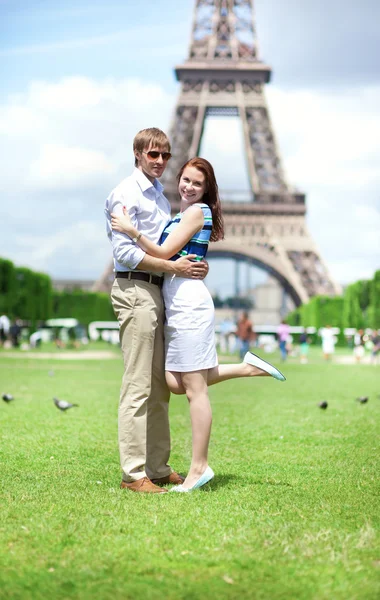 Primer plano de feliz pareja positiva abrazándose cerca de la torre Eiffel —  Fotos de Stock