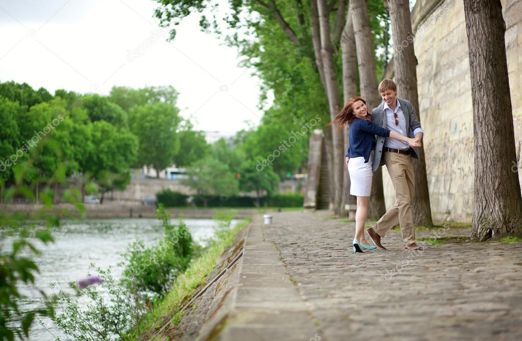 Happy couple is dancing on the Seine embankment in Paris