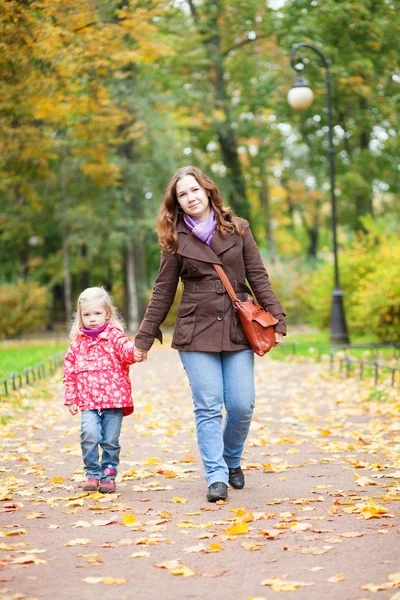Beautiful mother and daughter walking in autumn park together — Stock Photo, Image