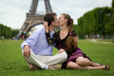 Paris 'te Eyfel Kulesi' nin yakınında öpüşen romantik bir çift.