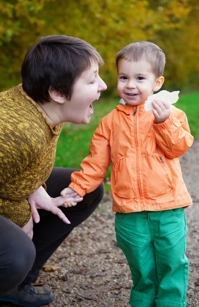 Mother and son having fun together in autumn forest — Stock Photo, Image