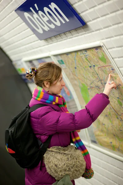 Turistické dívka v pařížském metru, při pohledu na mapu — Stock fotografie