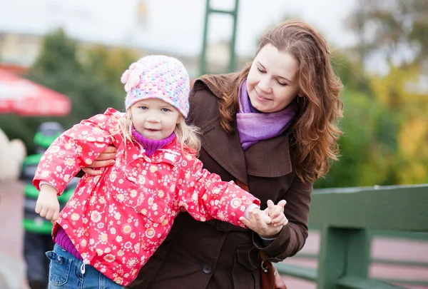 Außenporträt der jungen Mutter und ihrer schönen Tochter — Stockfoto