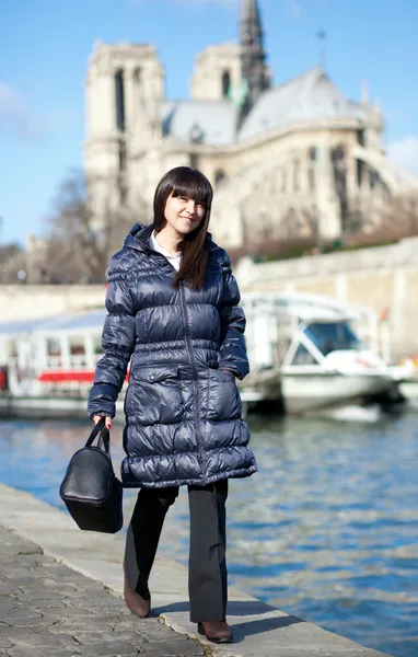 Beautiful brunette tourist walking at the emankment in Paris — Stockfoto