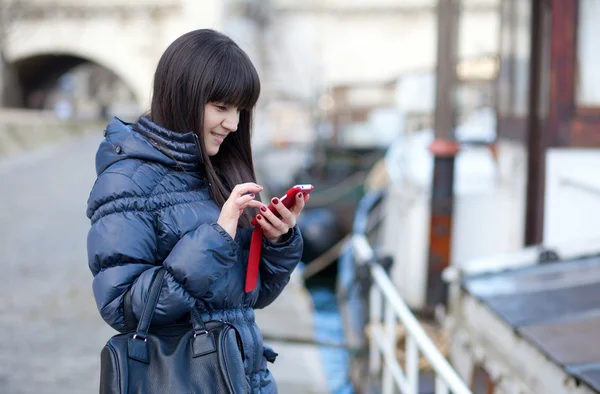 Feliz hermosa turista morena en París enviando un sms a un fr —  Fotos de Stock