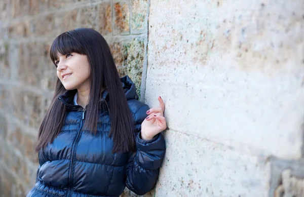 Portrait of beautiful brunette woman in front of the wall — Stock Photo, Image