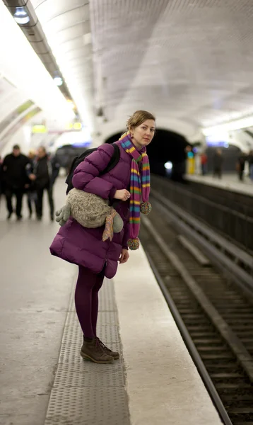 Tourist girl in bright clothes and funny bag waiting for the tra — Stock Photo, Image