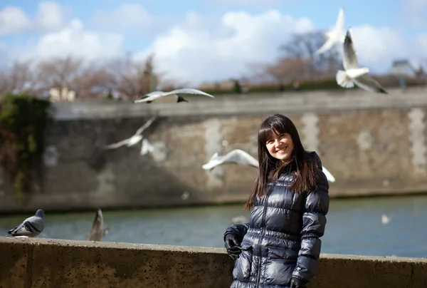 Menina morena feliz em aterro parisiense, gaivotas do mar voando em — Fotografia de Stock