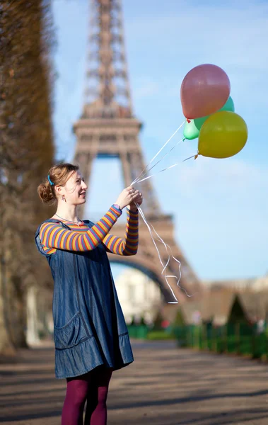 Menina em roupas brilhantes com balões coloridos em Paris, perto do — Fotografia de Stock