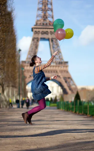 Girl in bright clothes jumping with colourful balloons in Paris — Stock Photo, Image