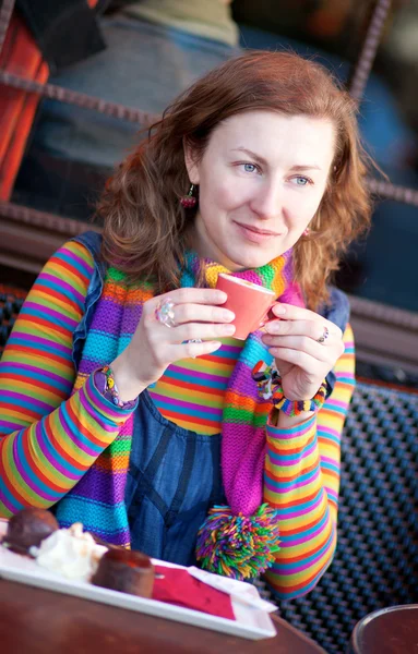 Piękna dziewczyna w kolorowe ubrania w kawiarni paryskiej uliczce — Zdjęcie stockowe